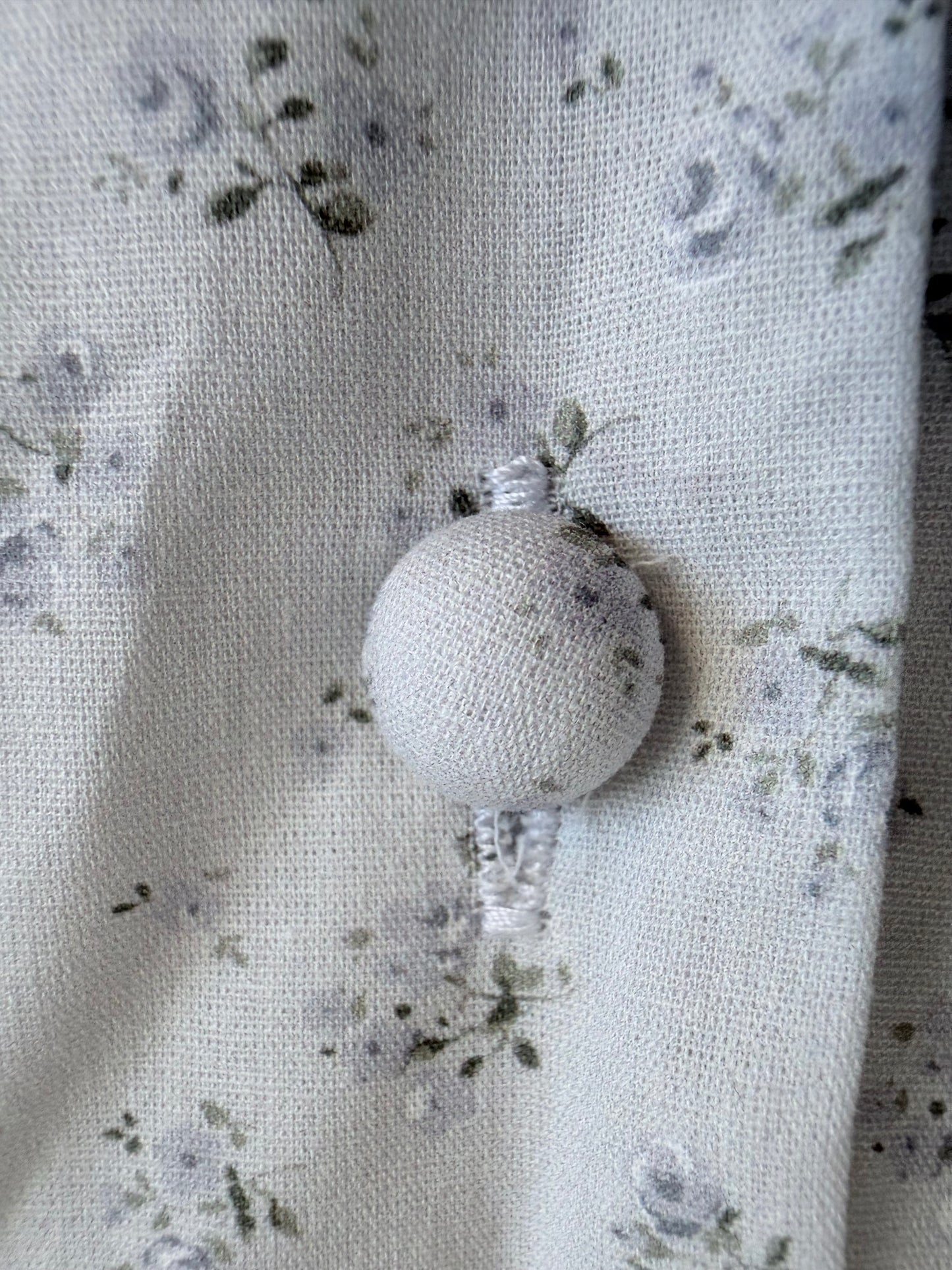 White spherical ornament on a floral fabric background