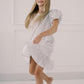 Girl  a white textured dress against a plain background