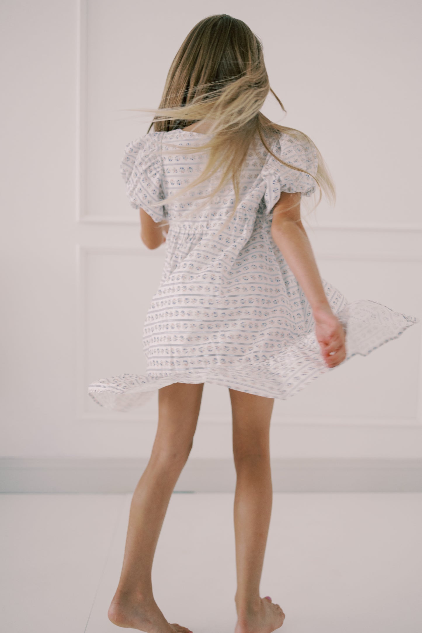 Person wearing a white textured dress against a plain background