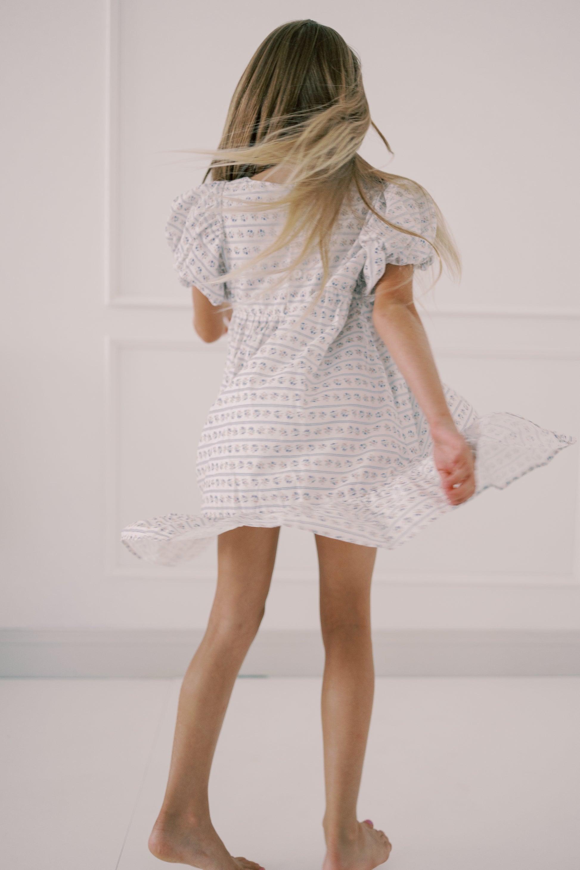 Person wearing a white textured dress against a plain background