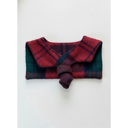Folded red and green plaid fabric on a white background