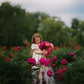 Young girl holding flowers in a garden with a blurred background